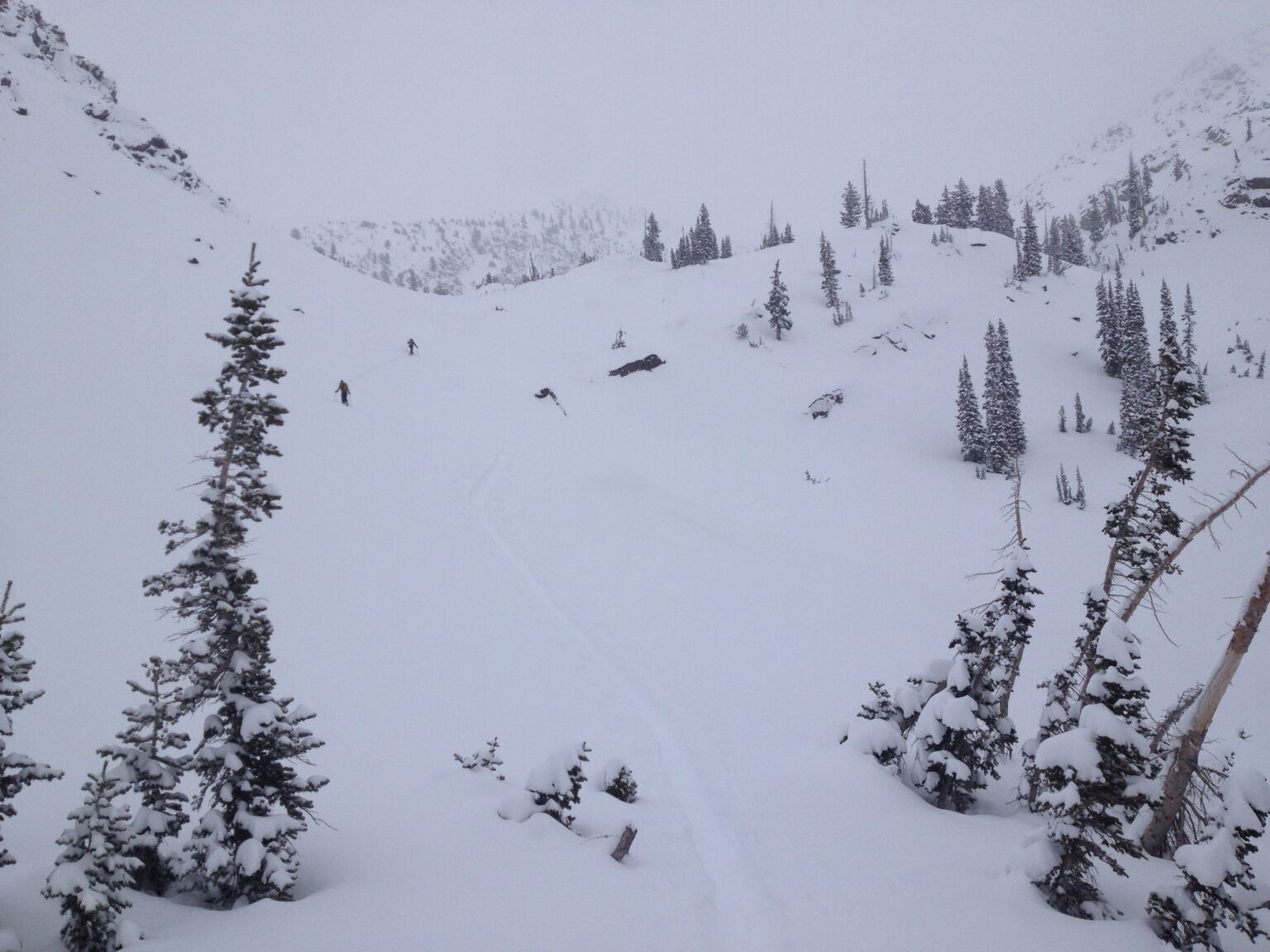 Ski touring up a gully in Lake Blanche Valley before snowboarding down White Pine Chute