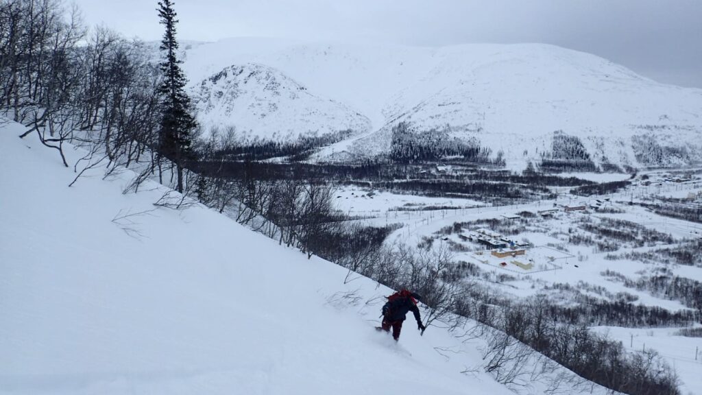 Snowboarding down with the Khibiny Mountains in the distance